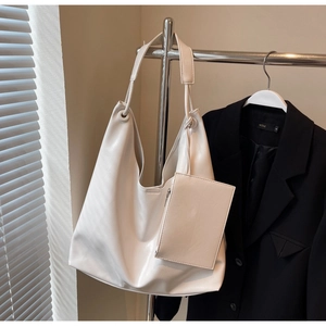 Detail of a creamy white large hobo shoulder bag with a matching small pouch on a hanger