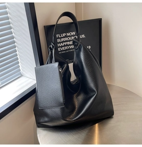 Détail de la texture cuir grainé noir du sac hobo avec sa petite pochette assortie