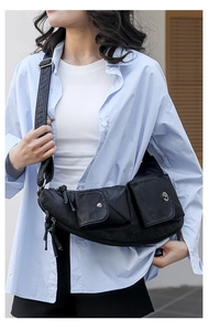 Détail du sac demi-lune en PU noir avec poches multiples et ferrures argentées élégantes