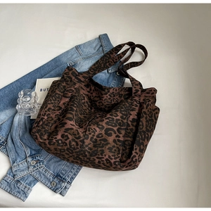 Dettaglio ravvicinato di una borsa tote leopardata in tela su una giacca di jeans