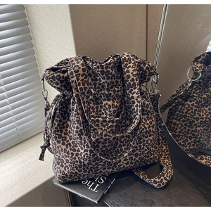 Detail view of leopard print canvas tote with drawstring side and wide shoulder strap