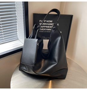 Détail du grand sac cabas noir en cuir grainé avec sa pochette rectangulaire assortie