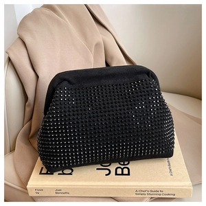 Macro view of black suede evening bag with glittering rhinestones and elegant gold clasp