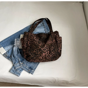 Dettaglio della grande borsa tote in tela leopardata con tasche laterali e manici robusti