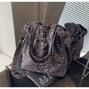 Detailed view of large leopard print tote bag with adjustable strap and metal hardware