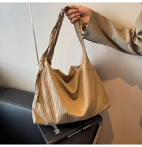 Detail der khakifarbenen Hobo-Schultertasche mit Cord-Faltenstruktur und Trageriemen