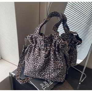 Detailed view of leopard print canvas bag with wide detachable strap and metal hook