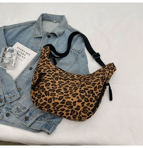 Detail of leopard print canvas crossbody bag with adjustable wide strap and zipper