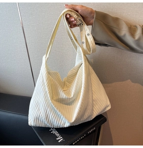 Detail der weißen Hobo-Tasche mit vertikaler Cord-Struktur und verstellbarem Gurt