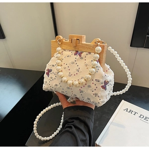 Detail view of decorative sequins and rhinestones on a white canvas shell bag