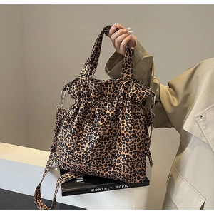 Detail of leopard print canvas tote bag featuring outer pocket and drawstring closure