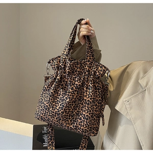 Detail of leopard print canvas tote bag featuring adjustable strap and drawstring closure