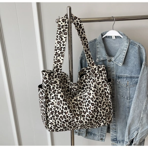 Dettaglio della borsa tote in tela leopardata con tasche laterali e spalline robuste