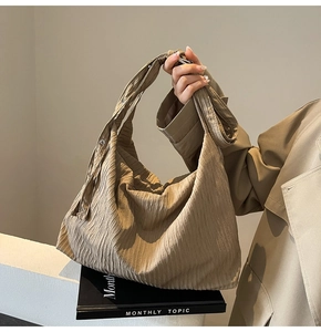 Detailansicht der khakifarbenen Cordtasche mit Plissee-Textur und verstellbarer Metallschnalle