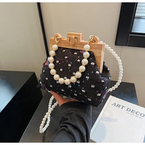 Detail of tweed evening bag with wooden frame, sequins and white pearl strap