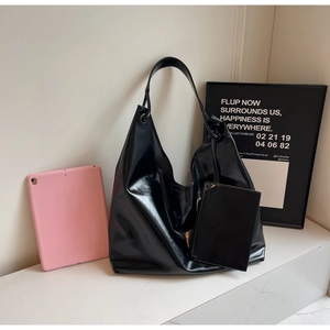 Detail view of large glossy black Hobo tote bag with matching coin purse and wide strap