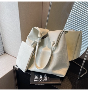 Détail du sac cabas blanc crème avec texture en cuir grainé et détail de bandoulière nouée