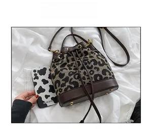 Detailed comparison showing leopard print bucket bag size next to a smartphone