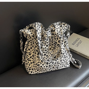 Detailed view of leopard print canvas tote bag with adjustable straps and metal hardware
