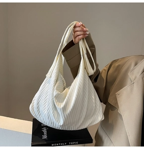 Detail einer weißen Cord-Tasche mit strukturierter Textur und schmalen Trägern