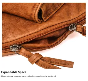 Détail du sac en cuir marron texturé montrant la conception à double fermeture éclair
