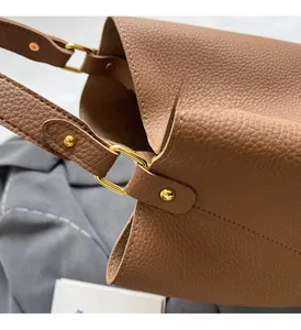 Détails du sac seau en cuir marron avec motif litchi et rivets dorés en métal