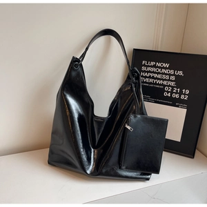 Close-up of black glossy patent leather tote with a detachable small zipper pouch set