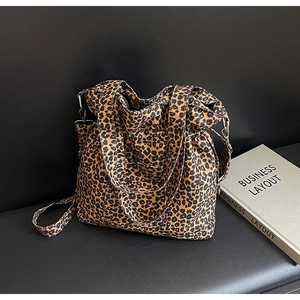 Detail view of large leopard print canvas tote bag showing textured fabric and strap