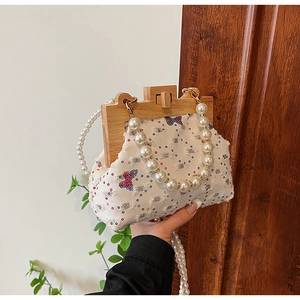 Detail of beaded pearl handle and wood frame on sequin butterfly shell bag