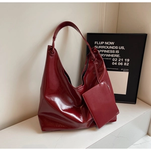 Detail of burgundy large hobo shoulder bag with glossy leather and matching mini pouch