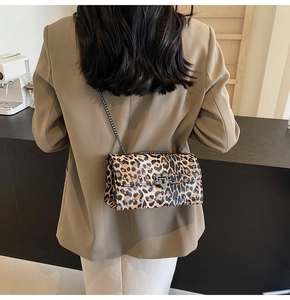 Sac bandoulière imprimé léopard avec rivets argentés et fermoir porté par un mannequin