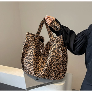 Dettaglio di una grande borsa tote leopardata con tasca laterale e trama in tela