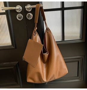 Gros plan sur un sac cabas caramel avec bandoulière nouée et mini pochette zippée assortie