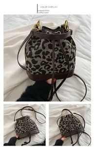 Detail of leopard print bucket bag featuring a drawstring closure and gold metal rings