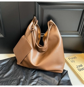 Détail d'un grand sac cabas en cuir grainé marron avec une petite pochette zippée assortie