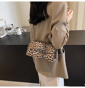 Détail du sac léopard avec rivets métalliques et fermoir vintage sur une bandoulière chaîne
