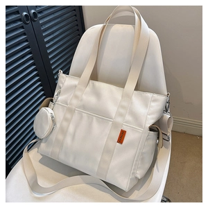 Detail of a beige nylon tote bag with wide strap and mini round coin purse attachment