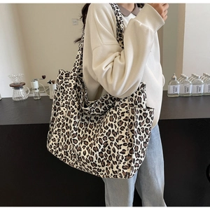 Dettaglio della borsa tote in tela leopardata con tasche laterali e tracolla coordinata