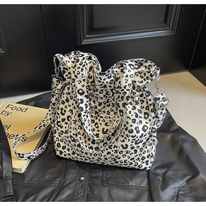 Detail of black and white leopard print tote bag with metallic hooks and wide handle