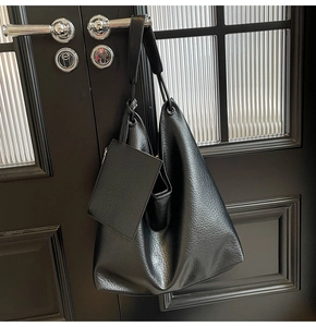 Détail du sac cabas en cuir grainé noir avec une petite pochette zippée assortie