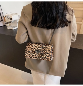 Détail du sac bandoulière léopard avec rivets métalliques et boucle argentée sur modèle