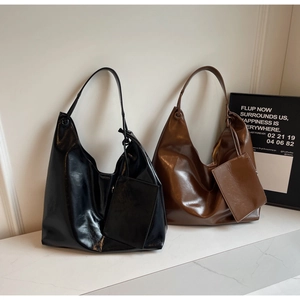 Detail of black and caramel brown leather shoulder bags with matching small pouch attachments