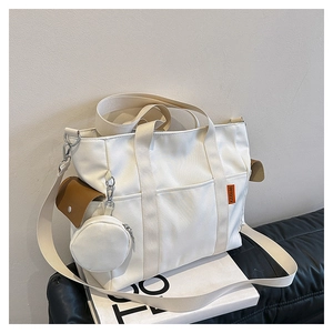 Detail of canvas tote bag with front pocket, side leather pouch and round coin purse