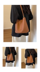 Détail du sac seau en cuir grainé marron avec finitions métalliques et bandoulière
