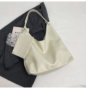 Détail du grand sac hobo blanc cassé avec pochette assortie sur une veste grise