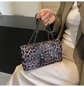 Détail du sac léopard avec clous argentés, fermoir rotatif et bandoulière chaîne