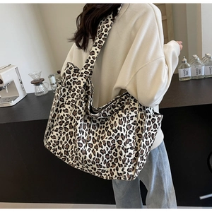 Dettaglio borsa tote in tela leopardata con tracolla larga e tasca laterale esterna
