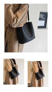 Détail de la texture cuir grainé et boucle dorée sur un sac seau noir élégant