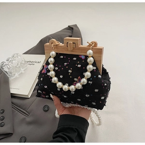 Close-up of vintage sequin bag featuring a wooden frame and elegant faux pearl handle