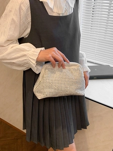 French luxury white shell bag with sparkling silver rhinestones held by a model
